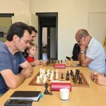 Adhésion au club l'échiquier Agenais, on voit une table sur laquelle des joueurs s'affrontes aux échecs. Gros moment de concentration.